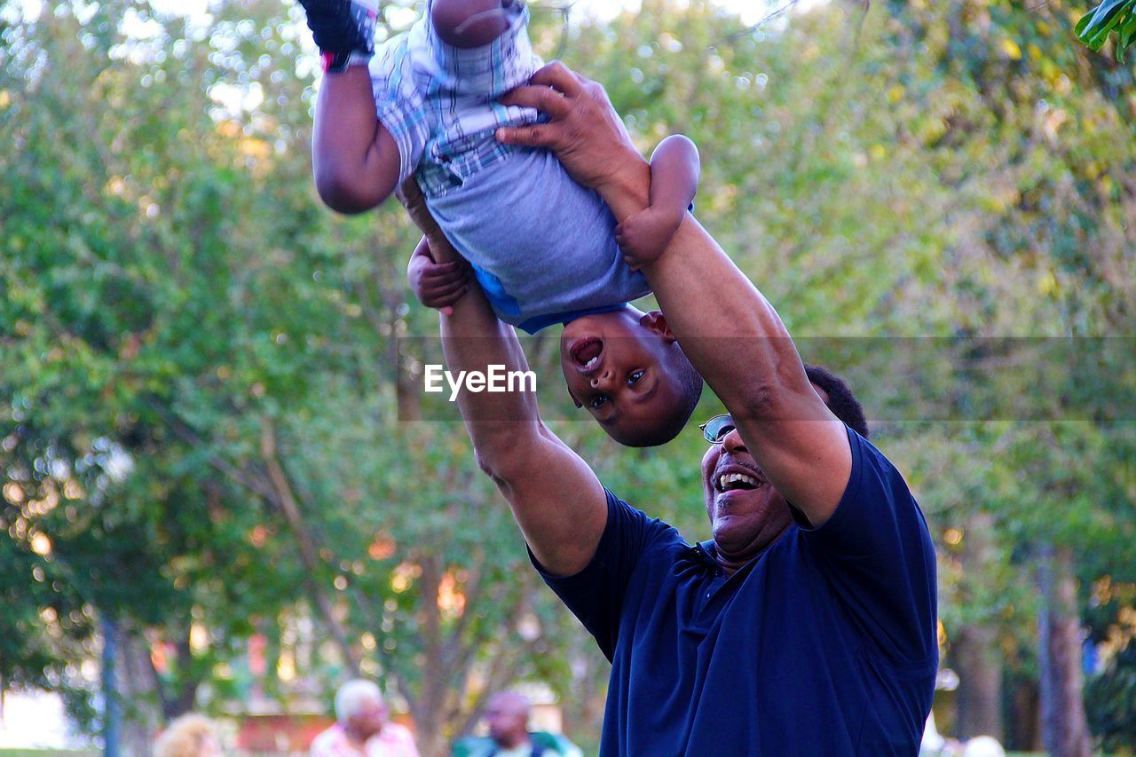 FULL LENGTH OF FATHER AND DAUGHTER PLAYING IN PARK