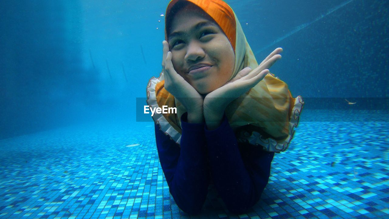 Portrait of young woman swimming in pool