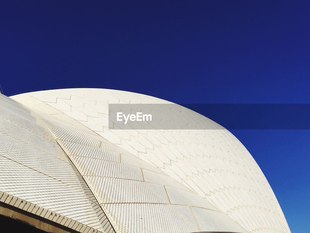 LOW ANGLE VIEW OF MODERN BUILDING AGAINST CLEAR BLUE SKY