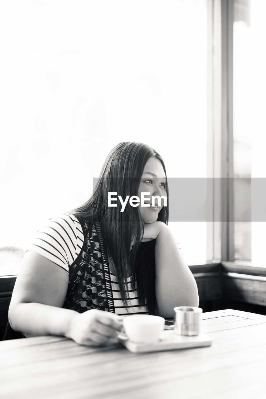 Portrait of young woman sitting at table