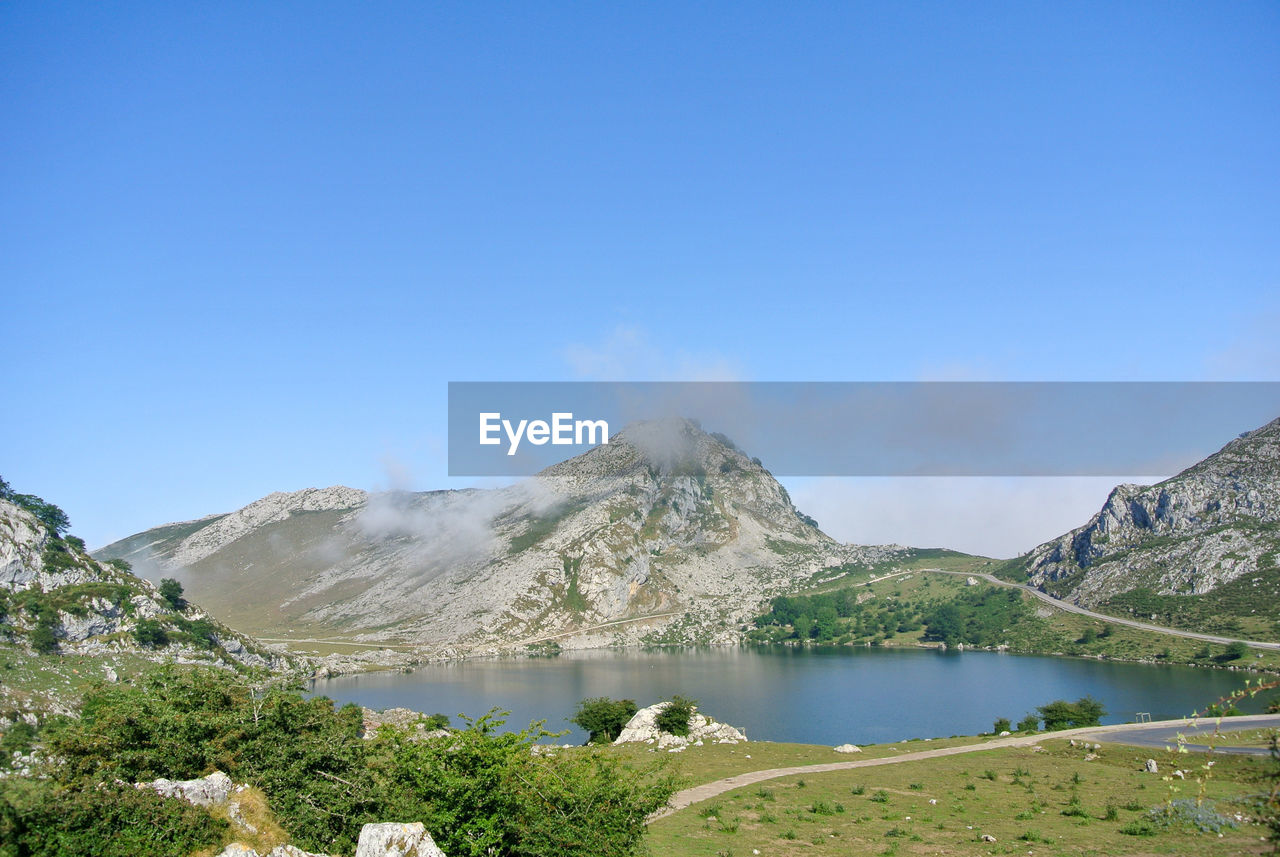 mountain, scenics - nature, water, sky, environment, beauty in nature, landscape, mountain range, nature, lake, blue, travel destinations, land, plant, no people, tranquility, travel, tranquil scene, non-urban scene, day, clear sky, tree, wilderness, tourism, outdoors, copy space, volcano, plateau, cloud, reservoir, mountain pass, idyllic, sunny, valley, geology, activity, mountain peak, highland