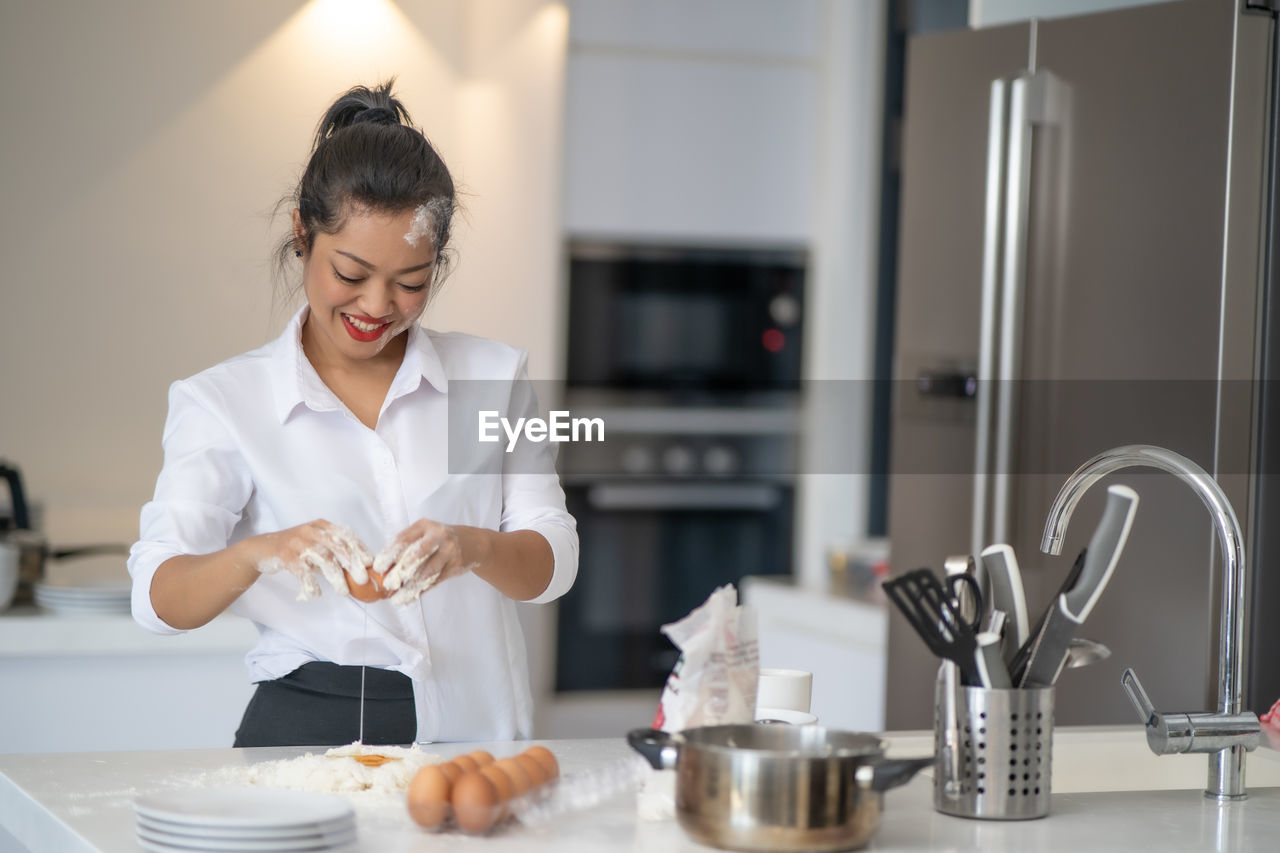 Smiling woman preparing food at home