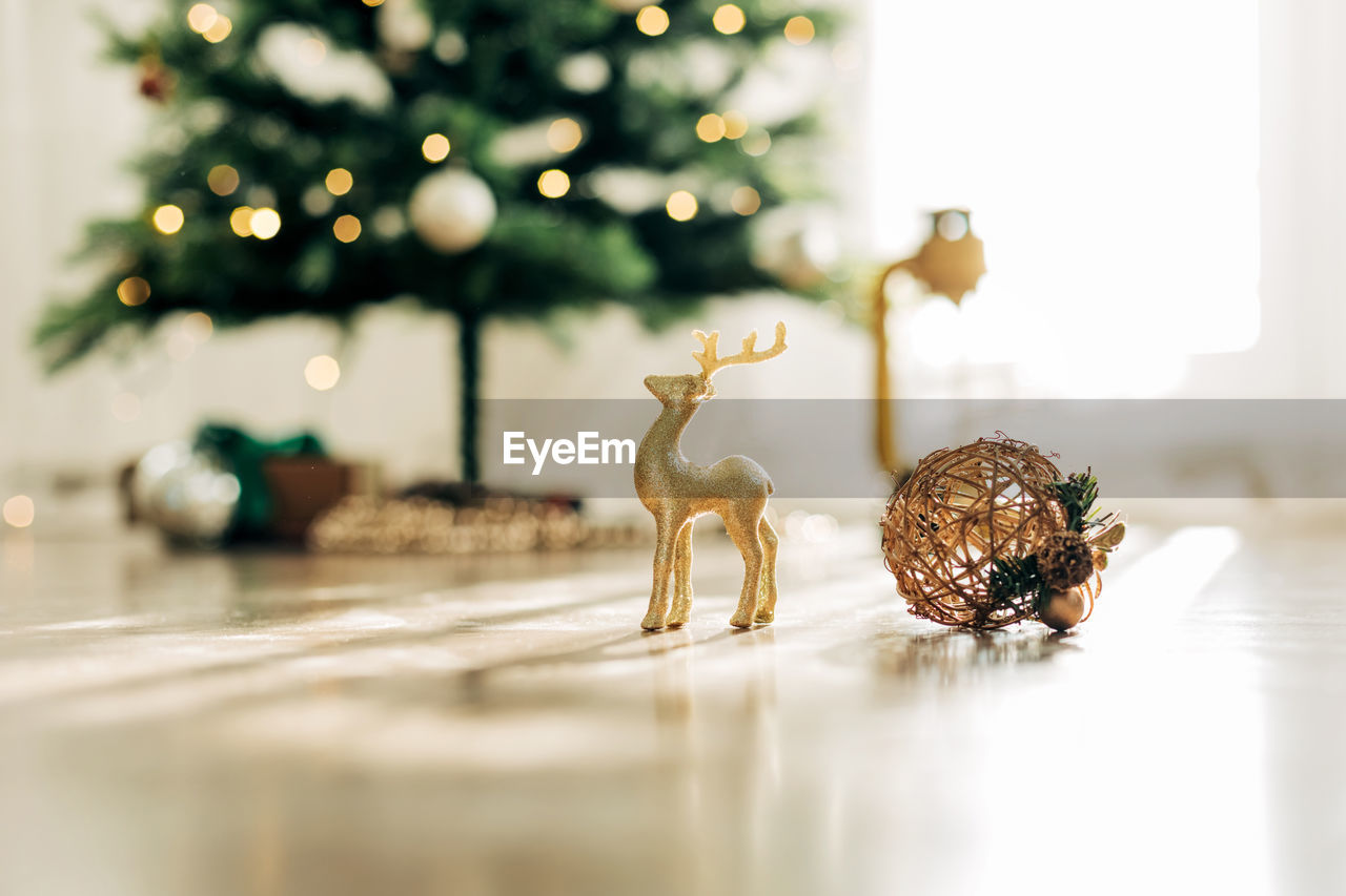 Golden deer and christmas ball on the background of the christmas tree, details of decorations. 