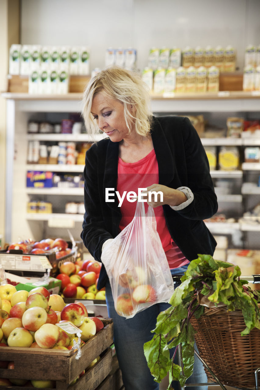 Mature woman choosing apples