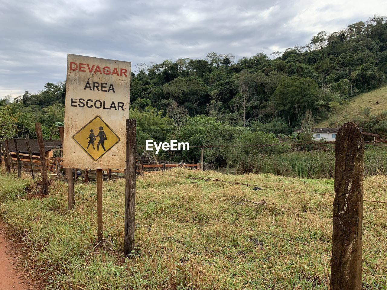 INFORMATION SIGN ON WOODEN POST AMIDST FIELD