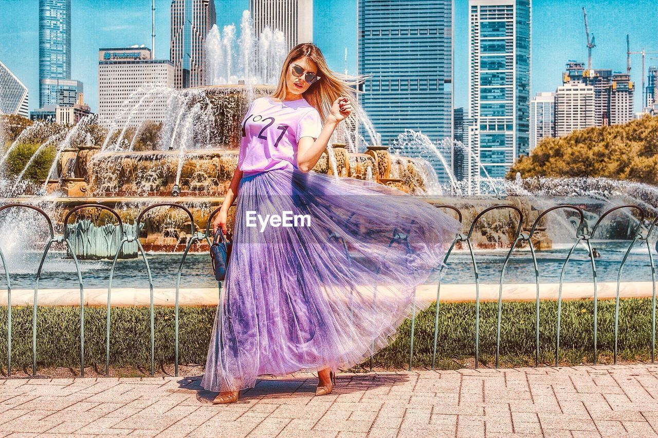 WOMAN STANDING BY BUILDING