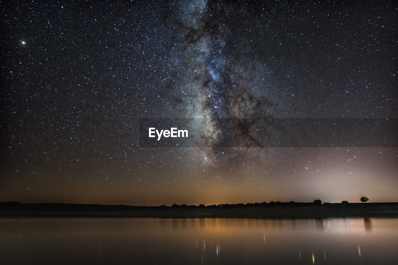 Scenic view of lake against star field at night