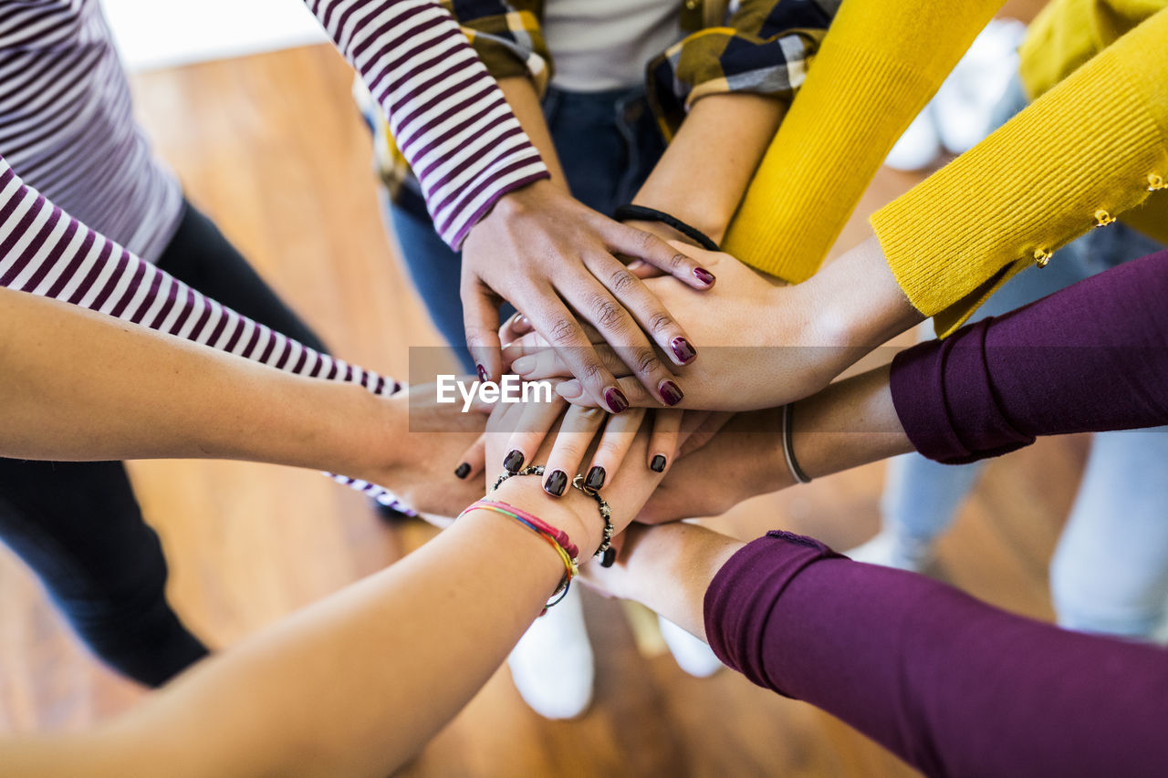 Close-up of five women stacking their hands