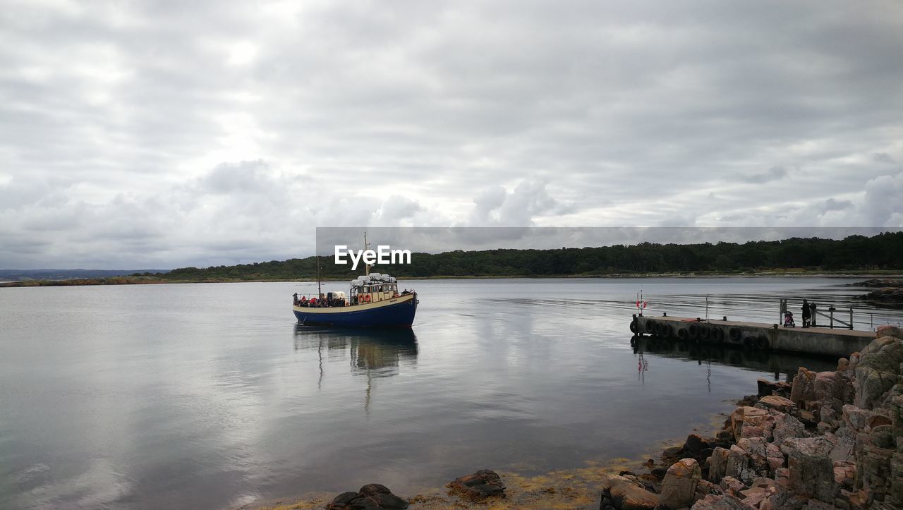 SHIP MOORED ON RIVER AGAINST SKY