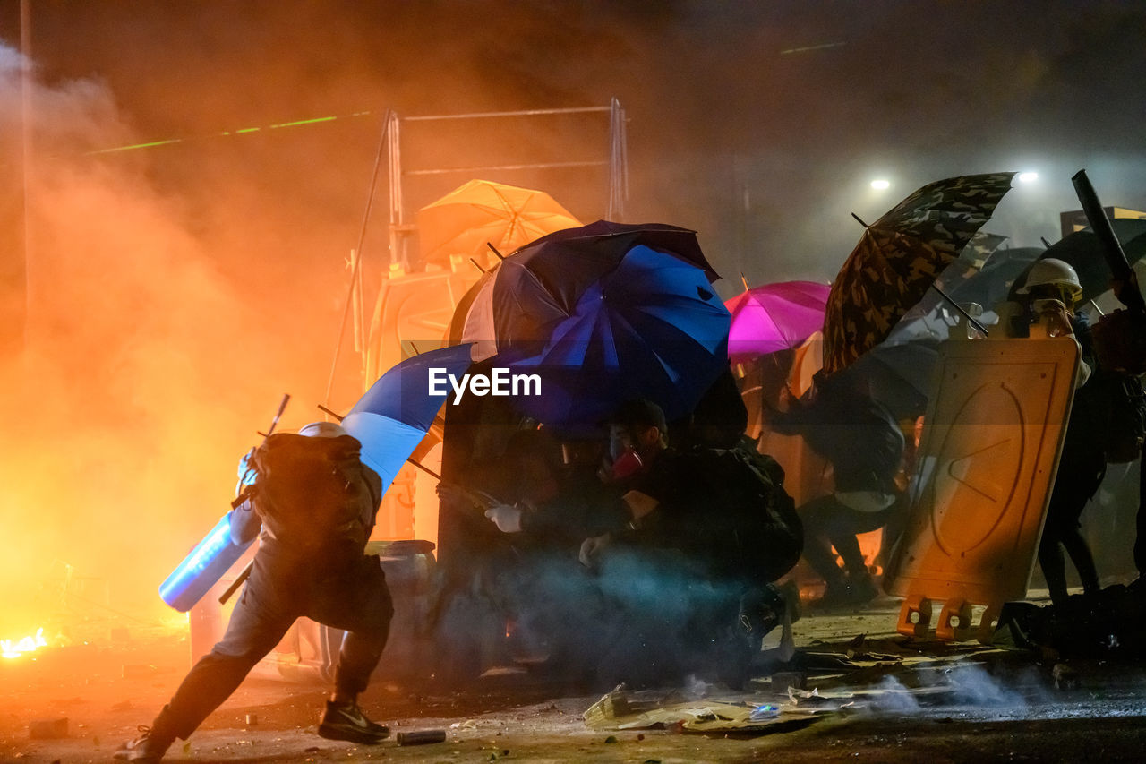 PEOPLE ON WET STREET IN CITY DURING FESTIVAL
