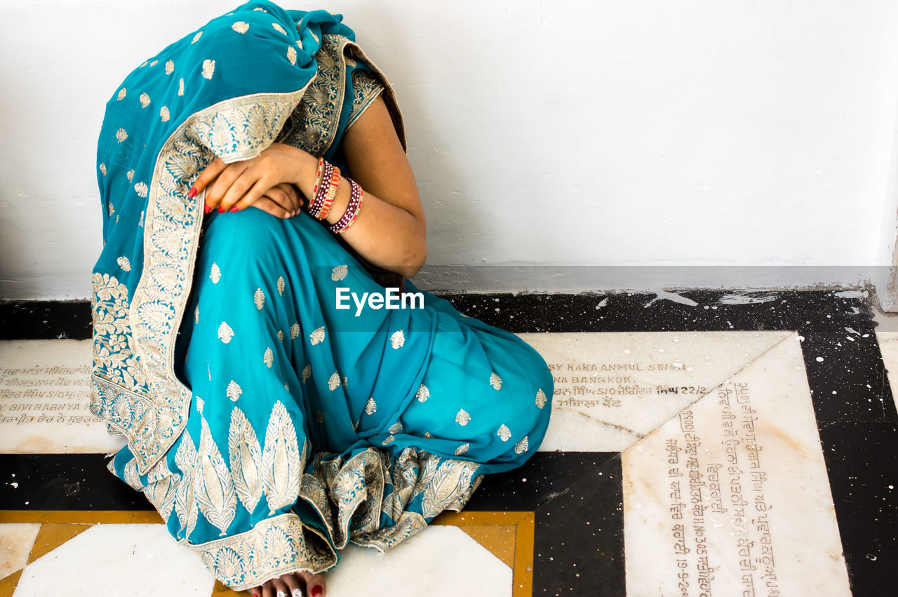 Woman wearing sari sitting on floor