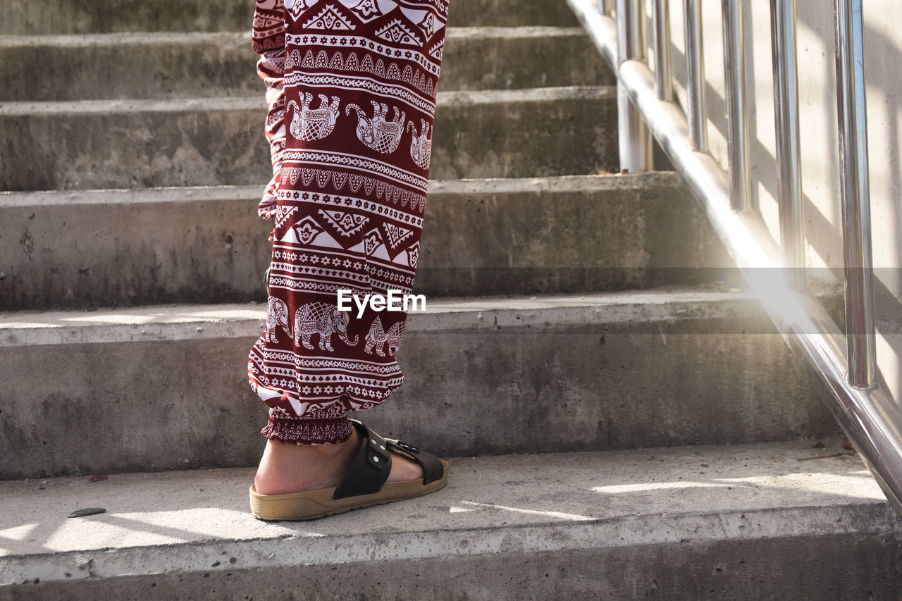 Low section of woman walking on staircase