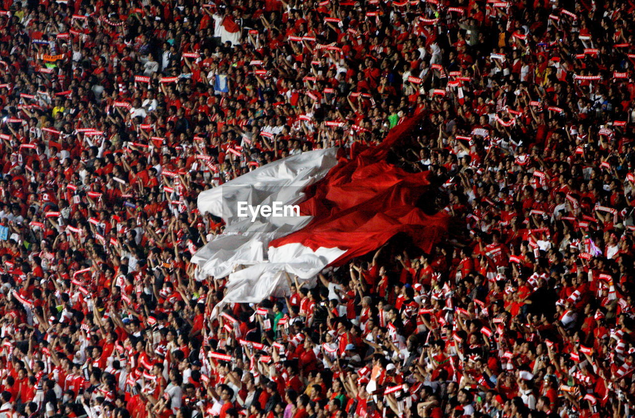 Spectators with indonesian flag in soccer stadium