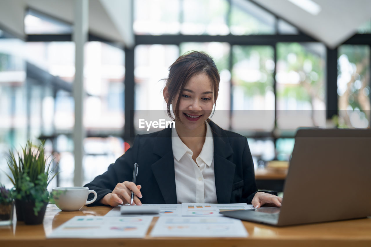 portrait of young businesswoman using laptop at office