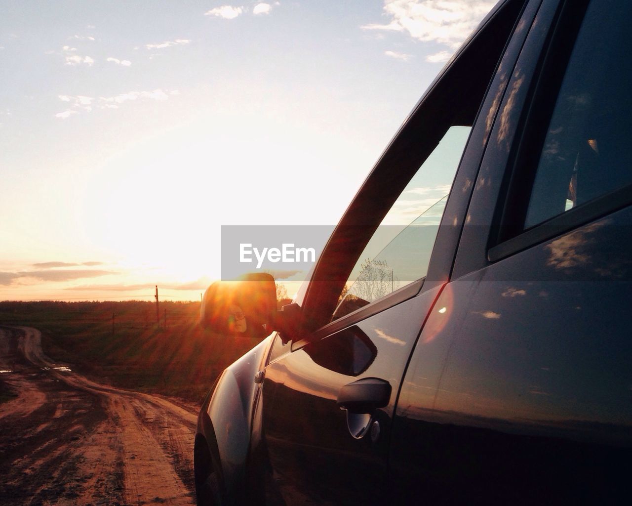 CLOSE-UP OF CAR AGAINST SUNSET SKY