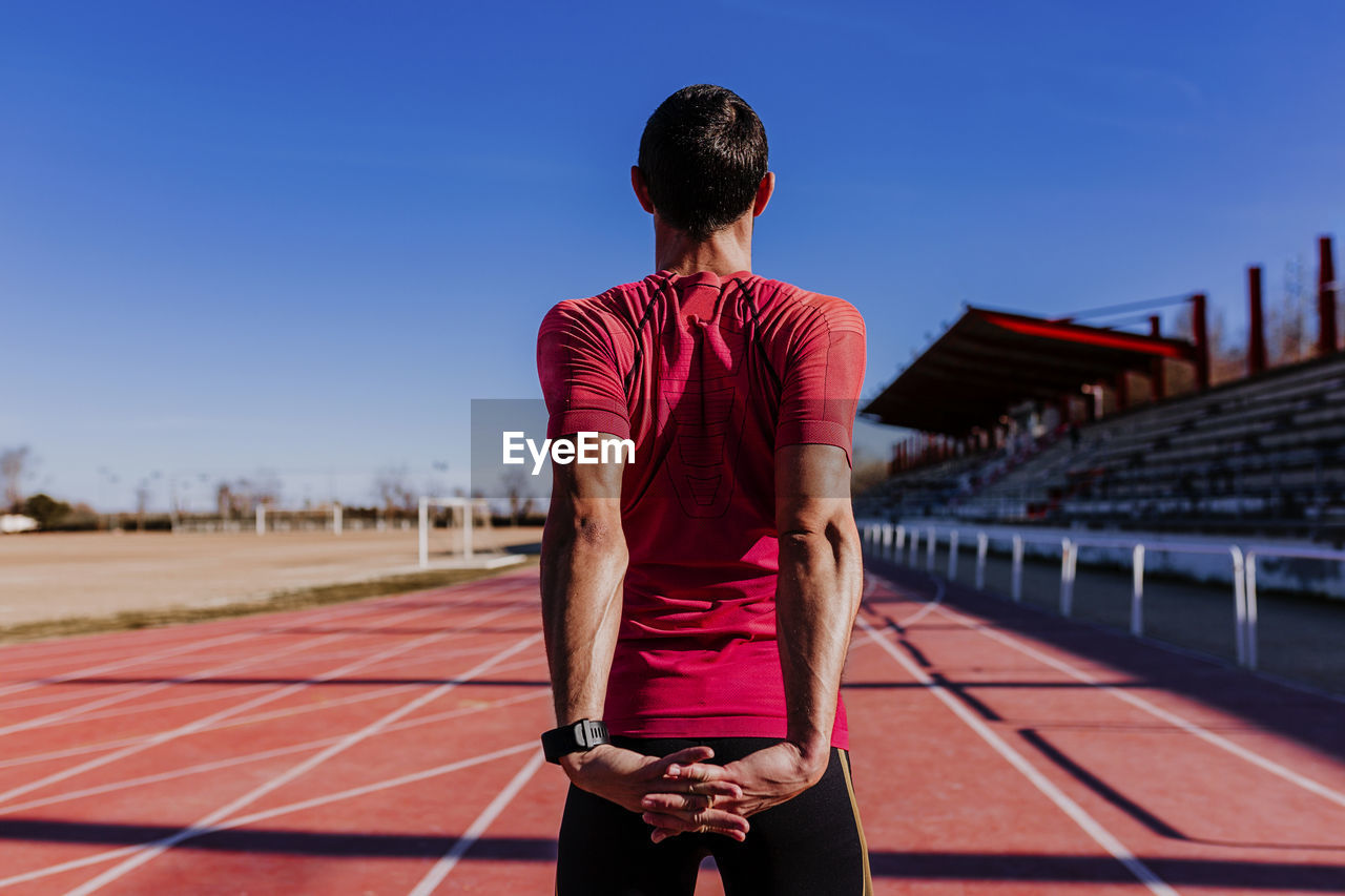 Rear view of athlete exercising on sports track