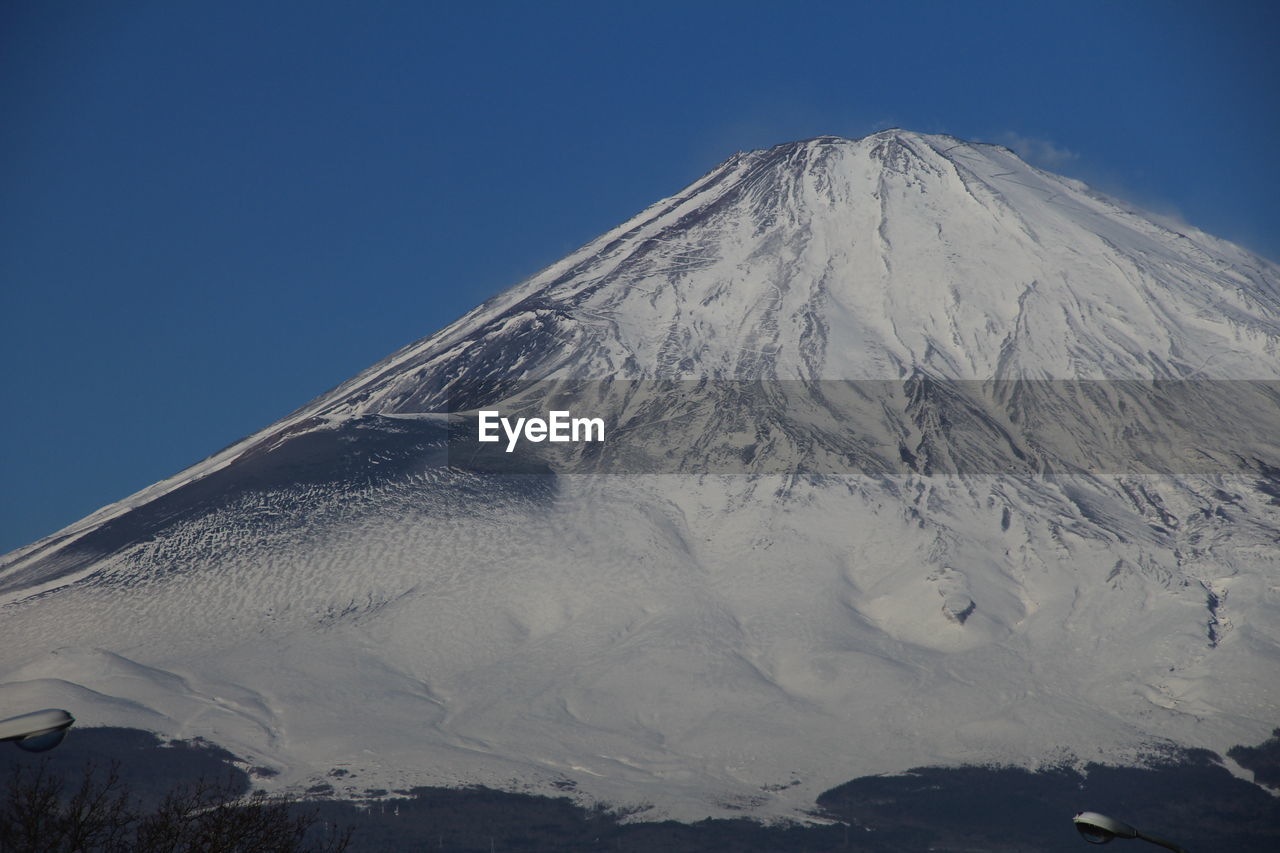 Scenic view of snow covered mountain against cloudy sky