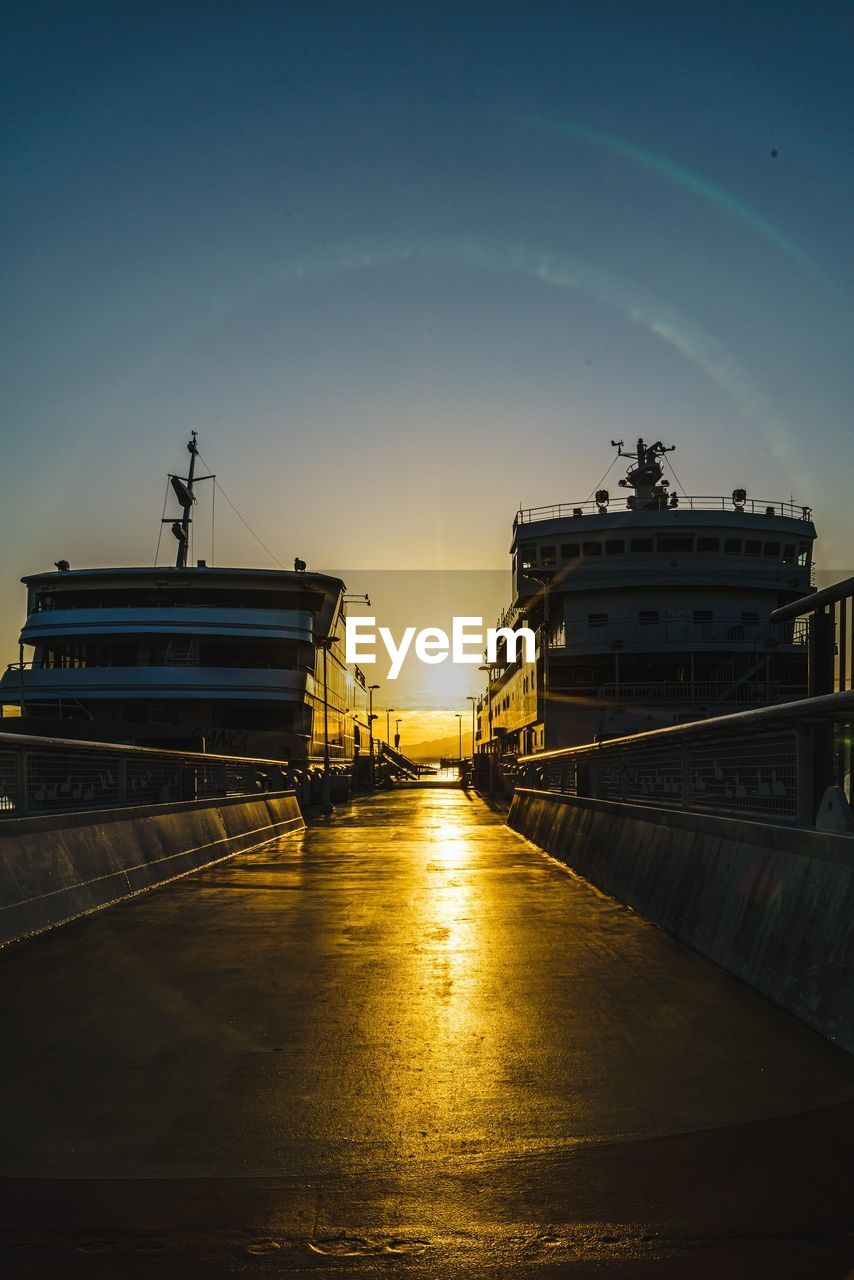 SHIP MOORED AT HARBOR AGAINST SKY