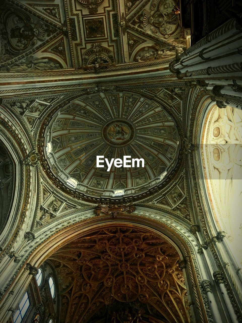 LOW ANGLE VIEW OF ORNATE CEILING OF CATHEDRAL