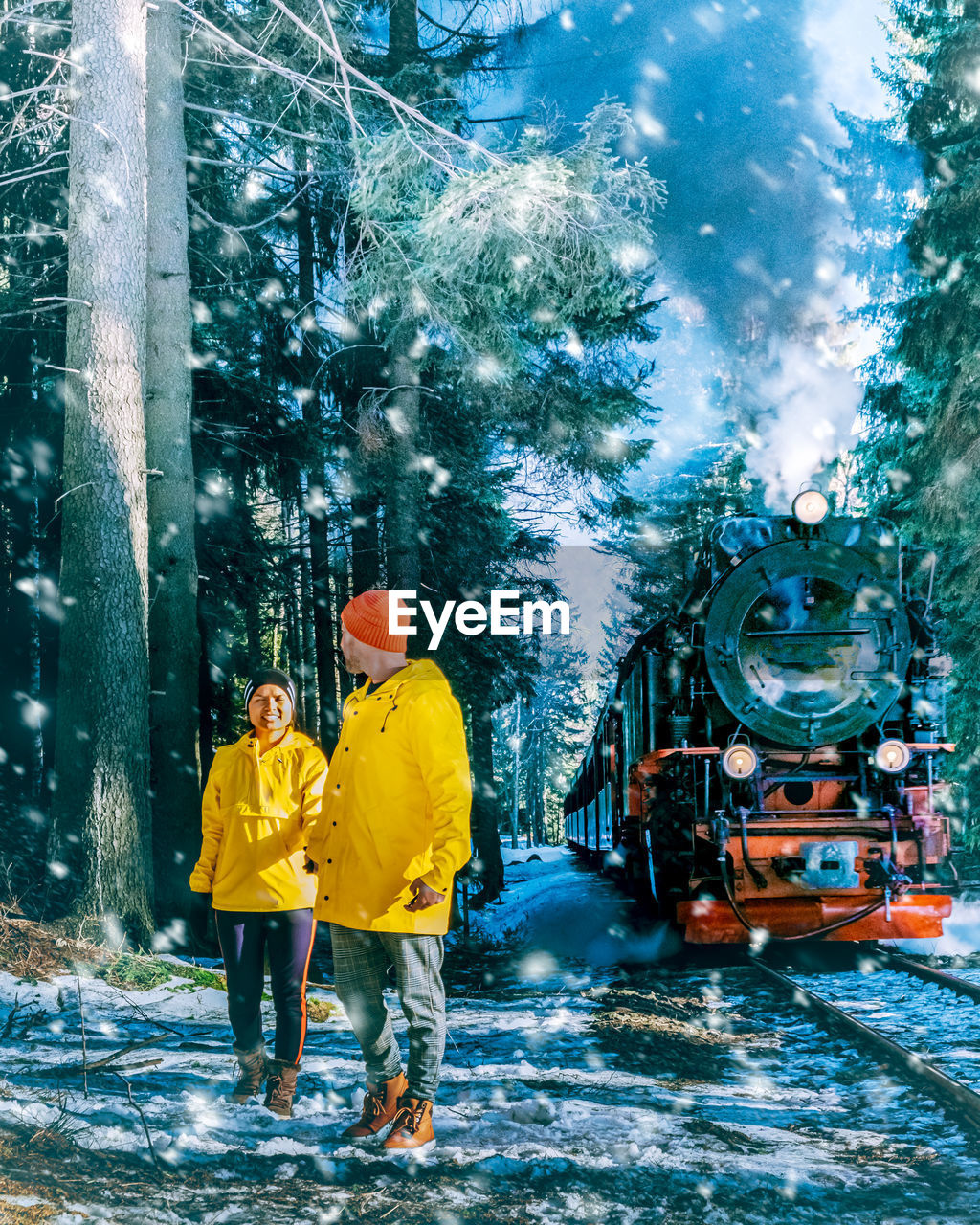 Couple standing on railroad tracks during winter