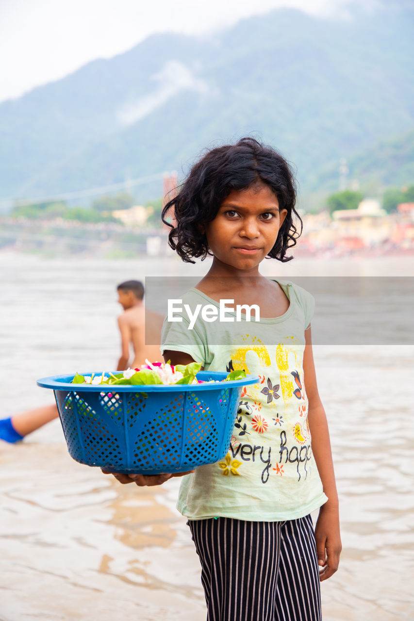 Portrait of young woman standing at ganga river