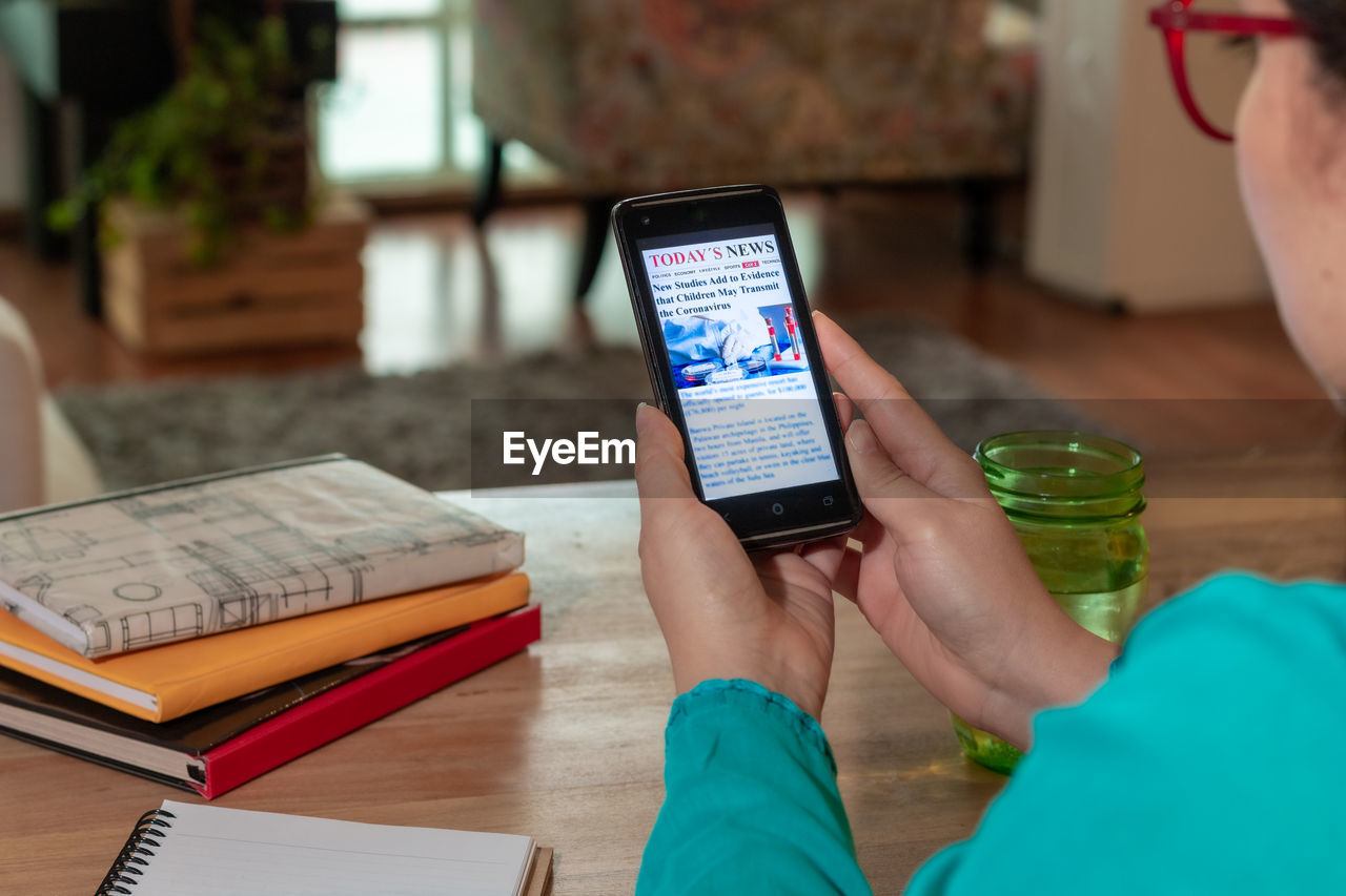 Woman reading coronavirus news on smart phone at home