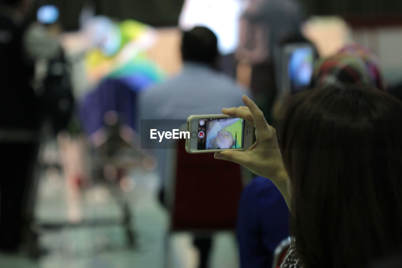 Close-up of woman filming with smart phone in operating room