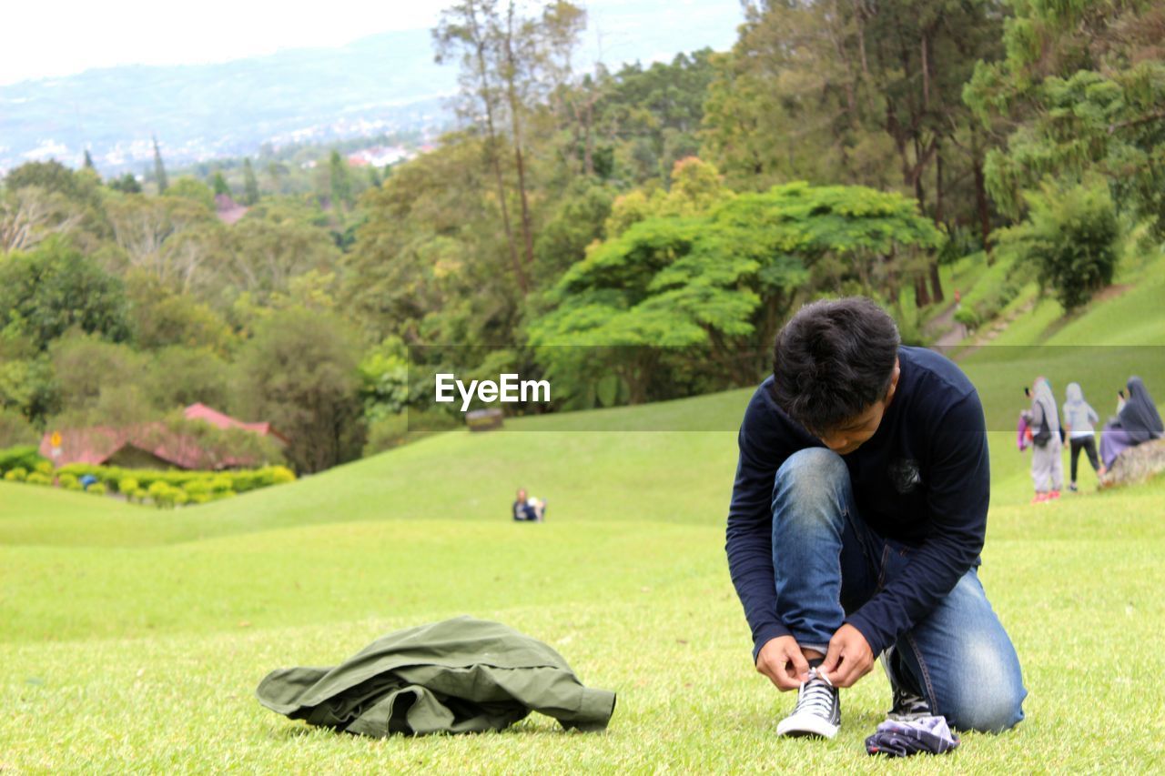 Man tying shoelace at golf course