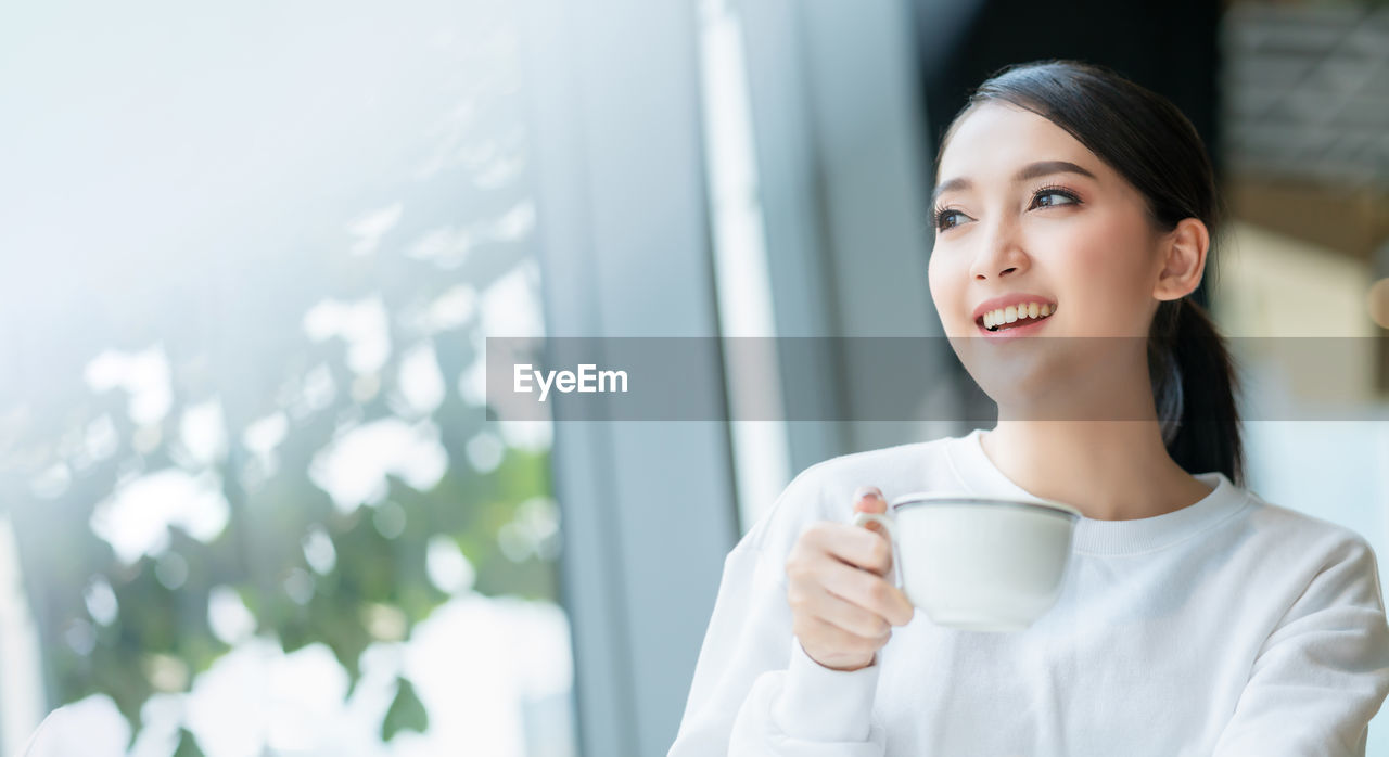 YOUNG WOMAN DRINKING COFFEE