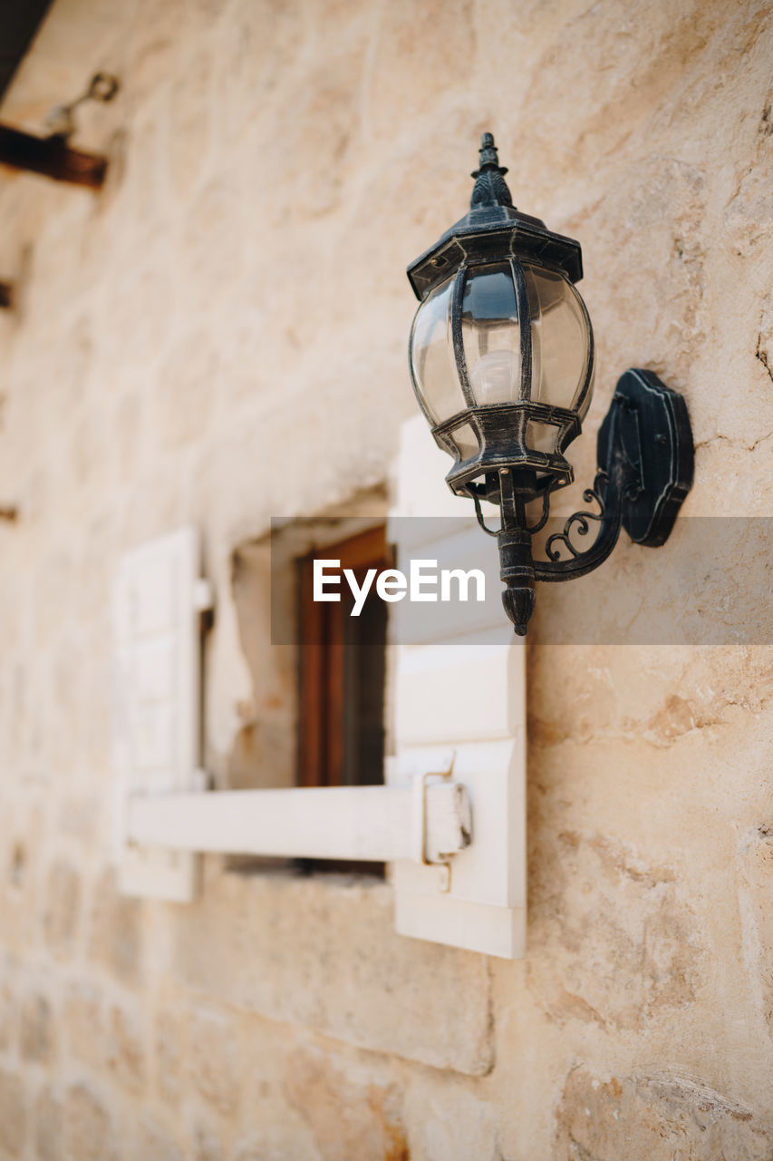 LOW ANGLE VIEW OF STREET LIGHT MOUNTED ON WALL