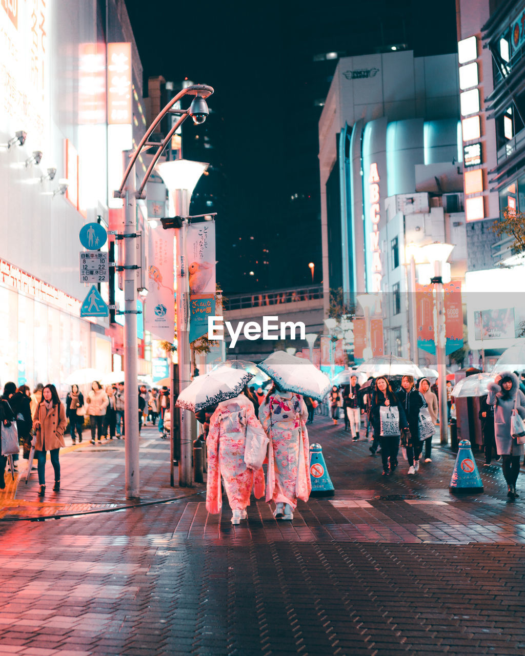 PEOPLE WALKING ON STREET IN CITY AT NIGHT