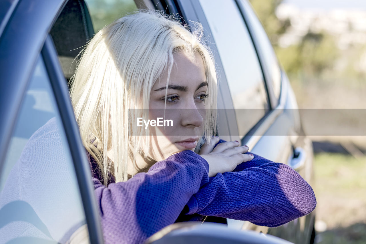 portrait of young woman looking away in car