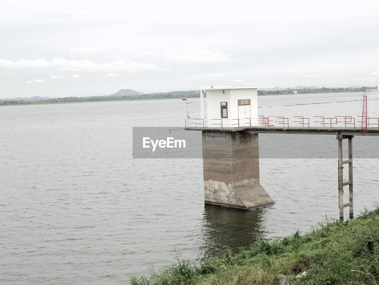 BUILT STRUCTURE ON RIVERBANK AGAINST SKY