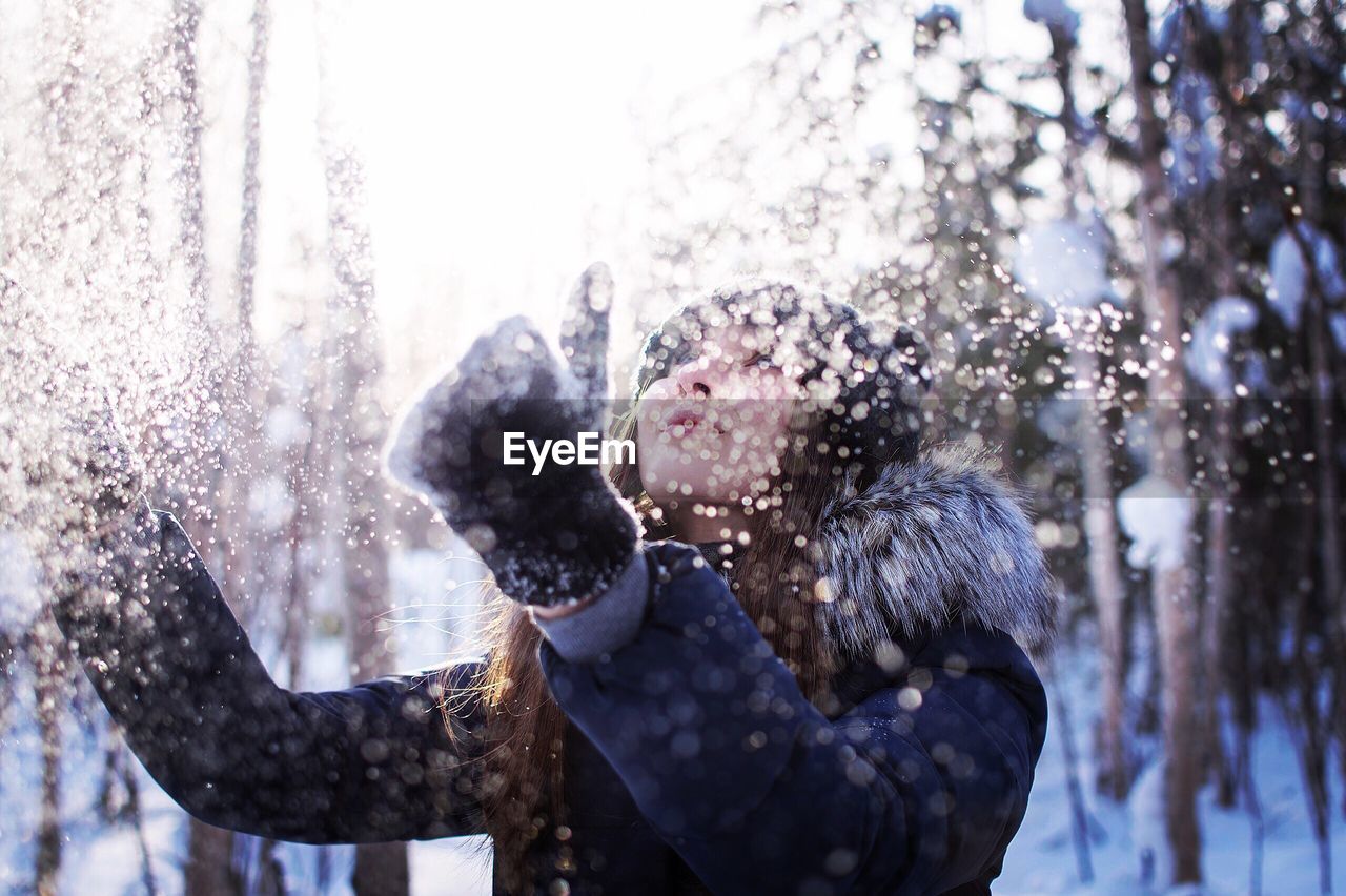 Woman having fun with snow during winter