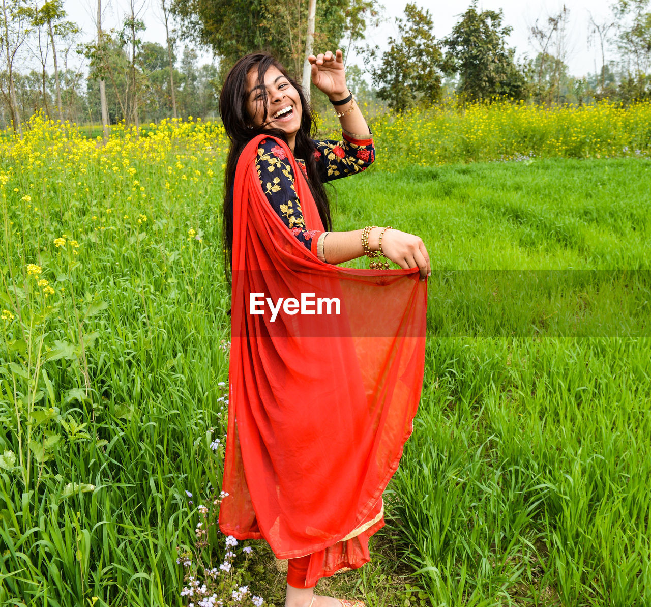 Portrait of laughing teenage girl standing on agricultural field