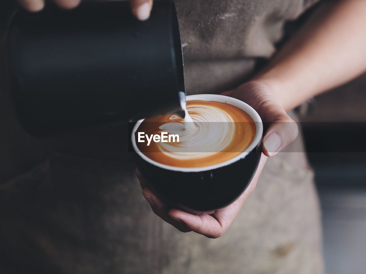 Midsection of person preparing coffee at cafe