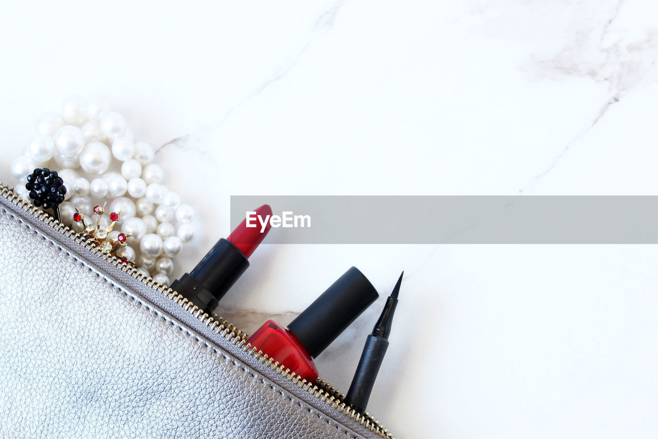 High angle view of make-up accessories in pouch on table