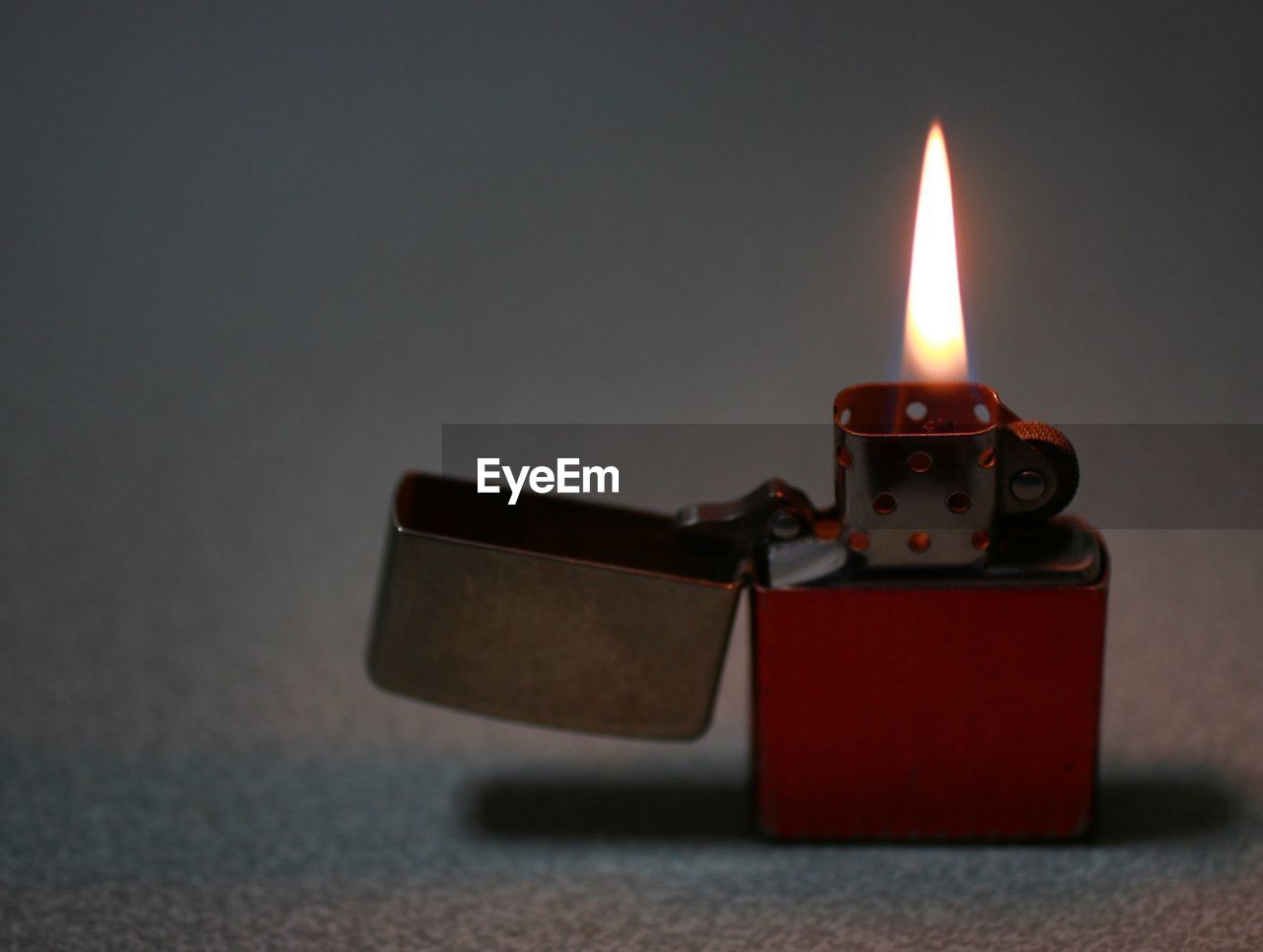 Close-up of illuminated cigarette lighter on table