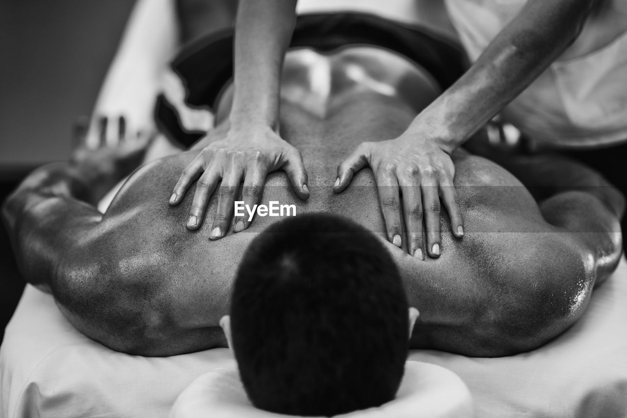 Cropped image of man massaging male customer at spa