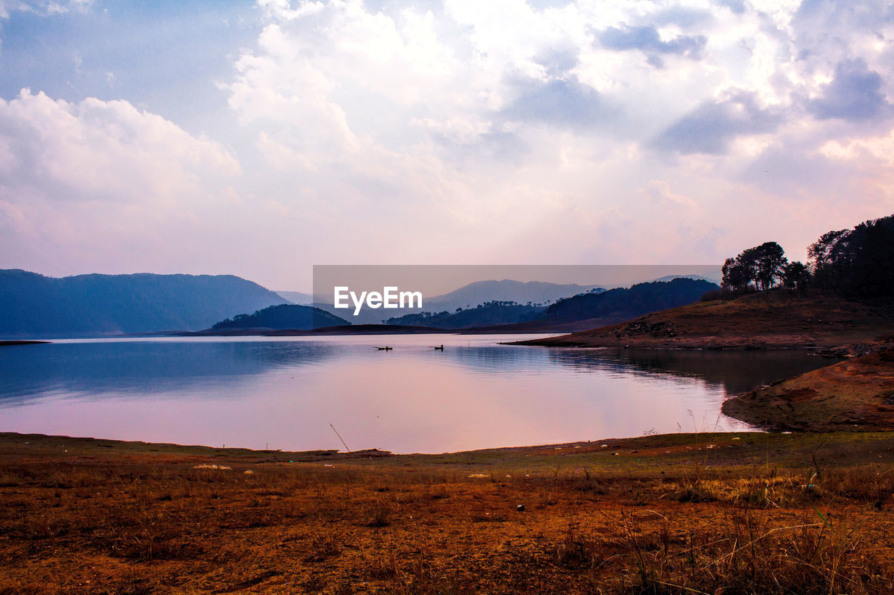 Scenic view of lake against cloudy sky