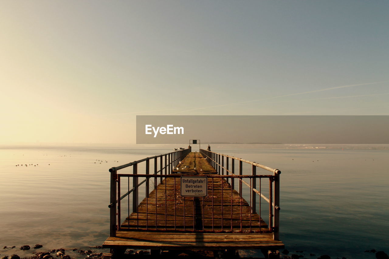 Pier over sea against clear sky