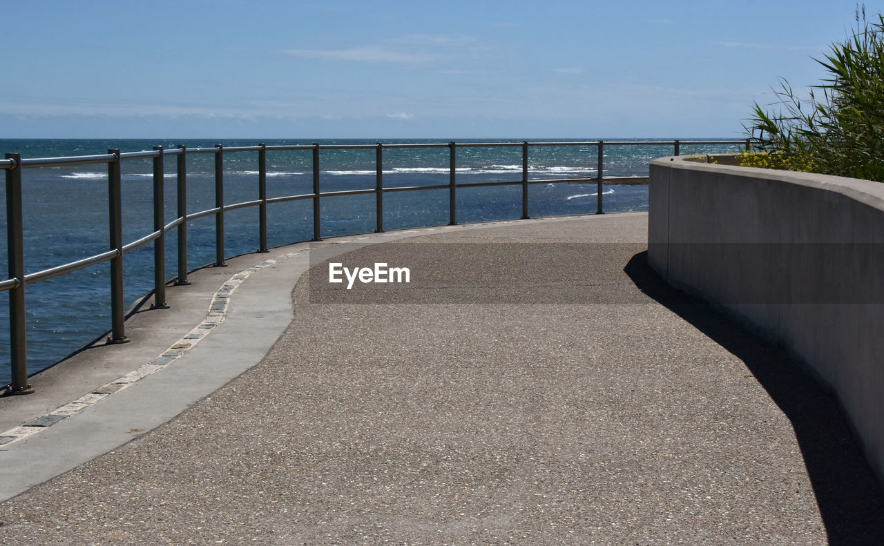 WALKWAY BY SEA AGAINST SKY