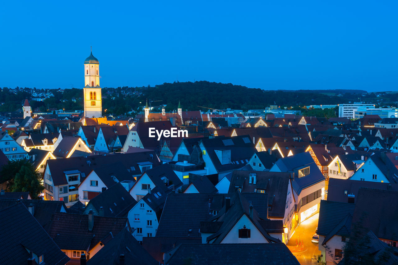 High angle view of illuminated buildings against blue sky