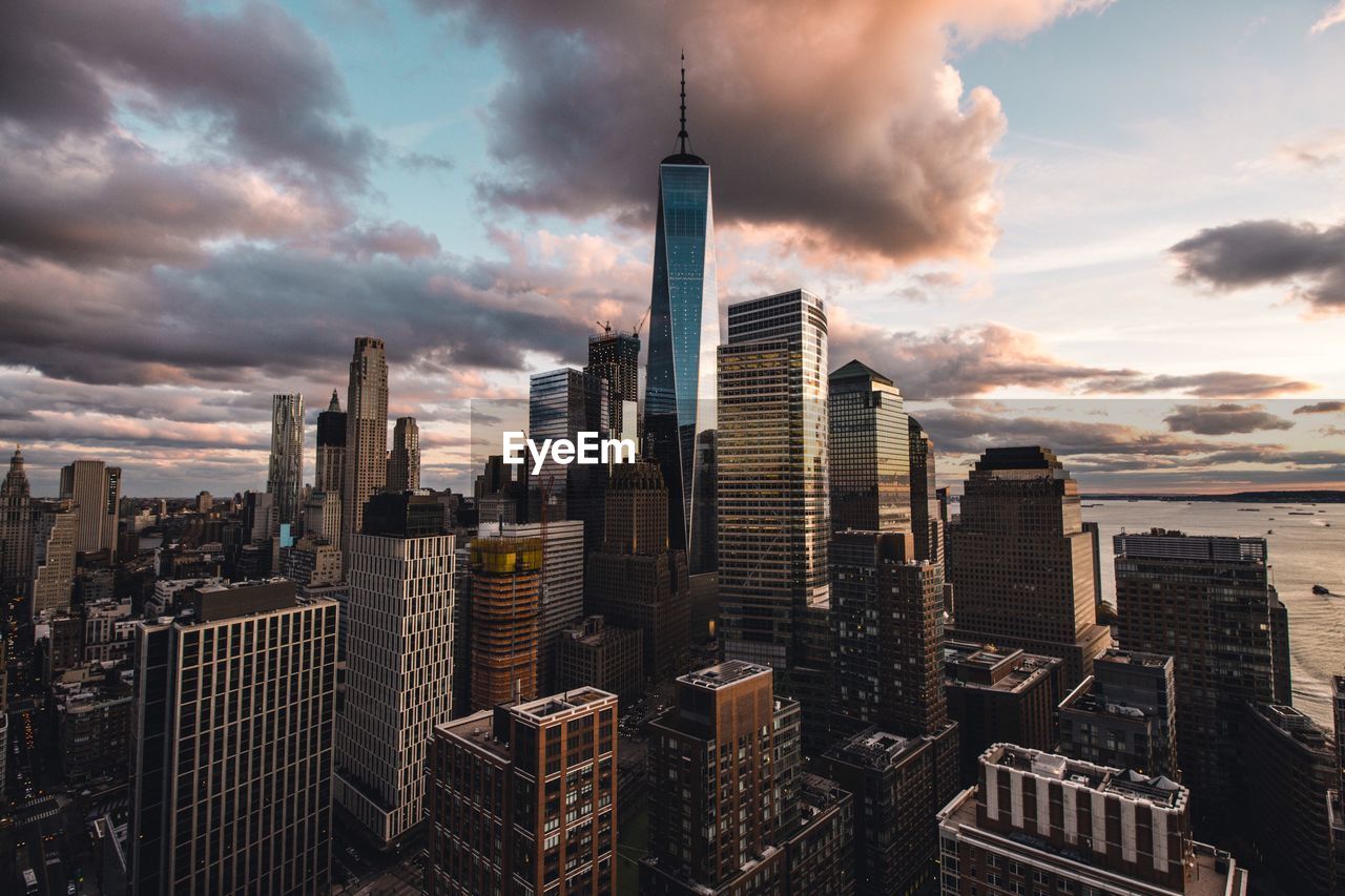 Skyscrapers in city against cloudy sky