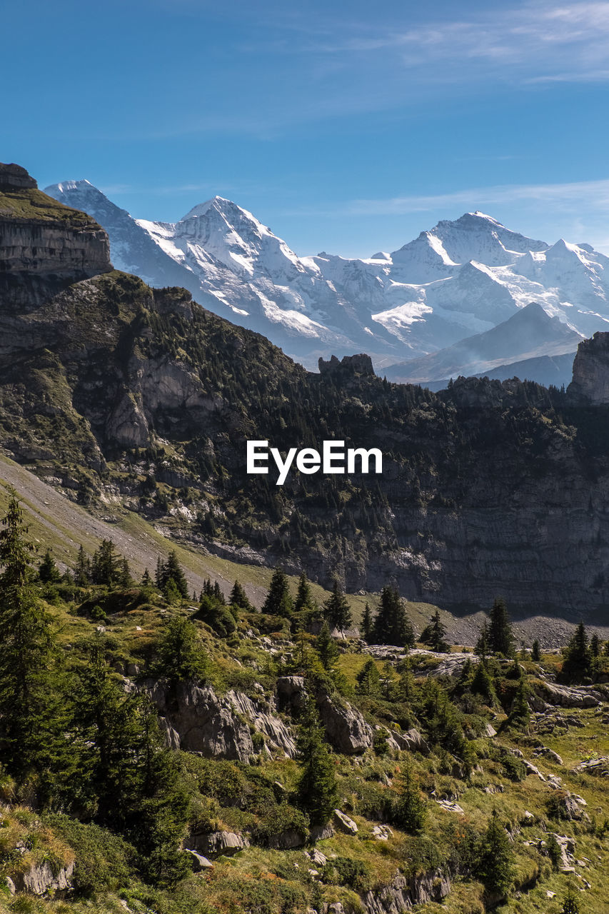 Scenic view of snowcapped mountains against blue sky