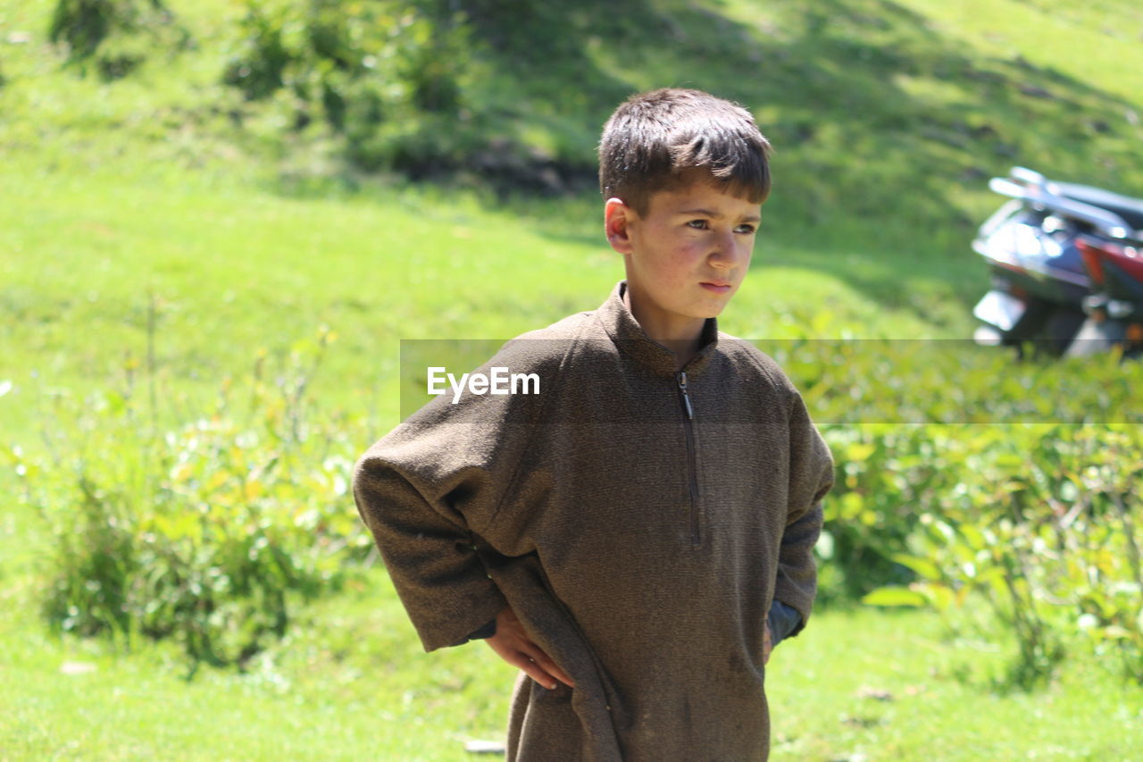 A cute kashmiri boy in his traditional dress in pine woods