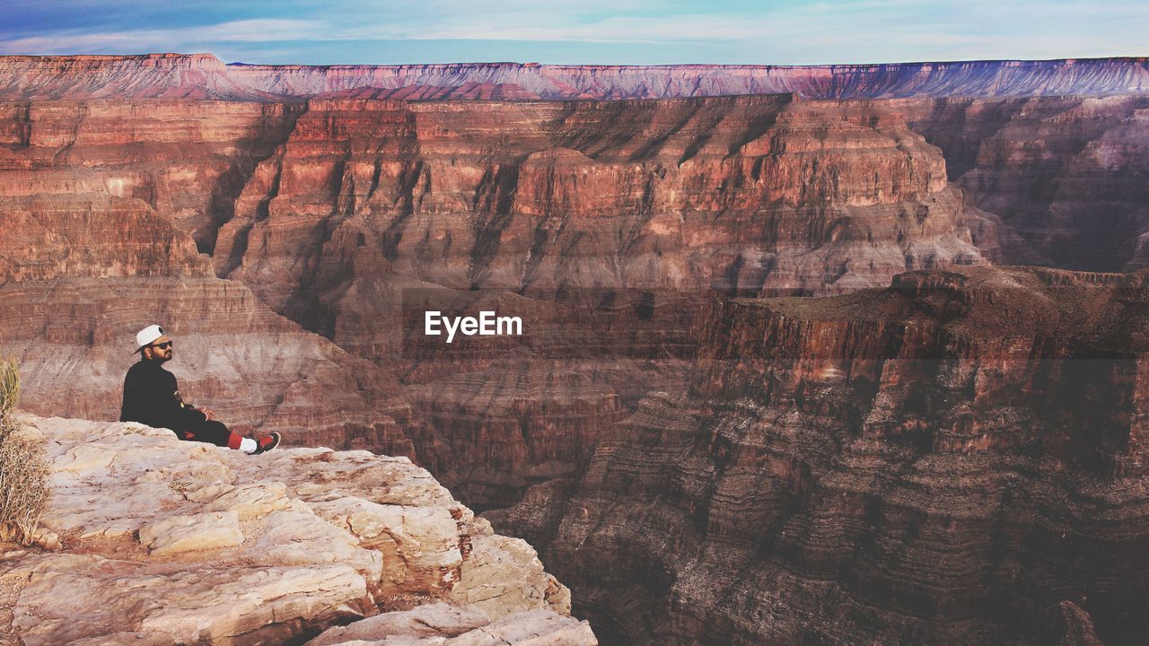 Man sitting on cliff at grand canyon national park
