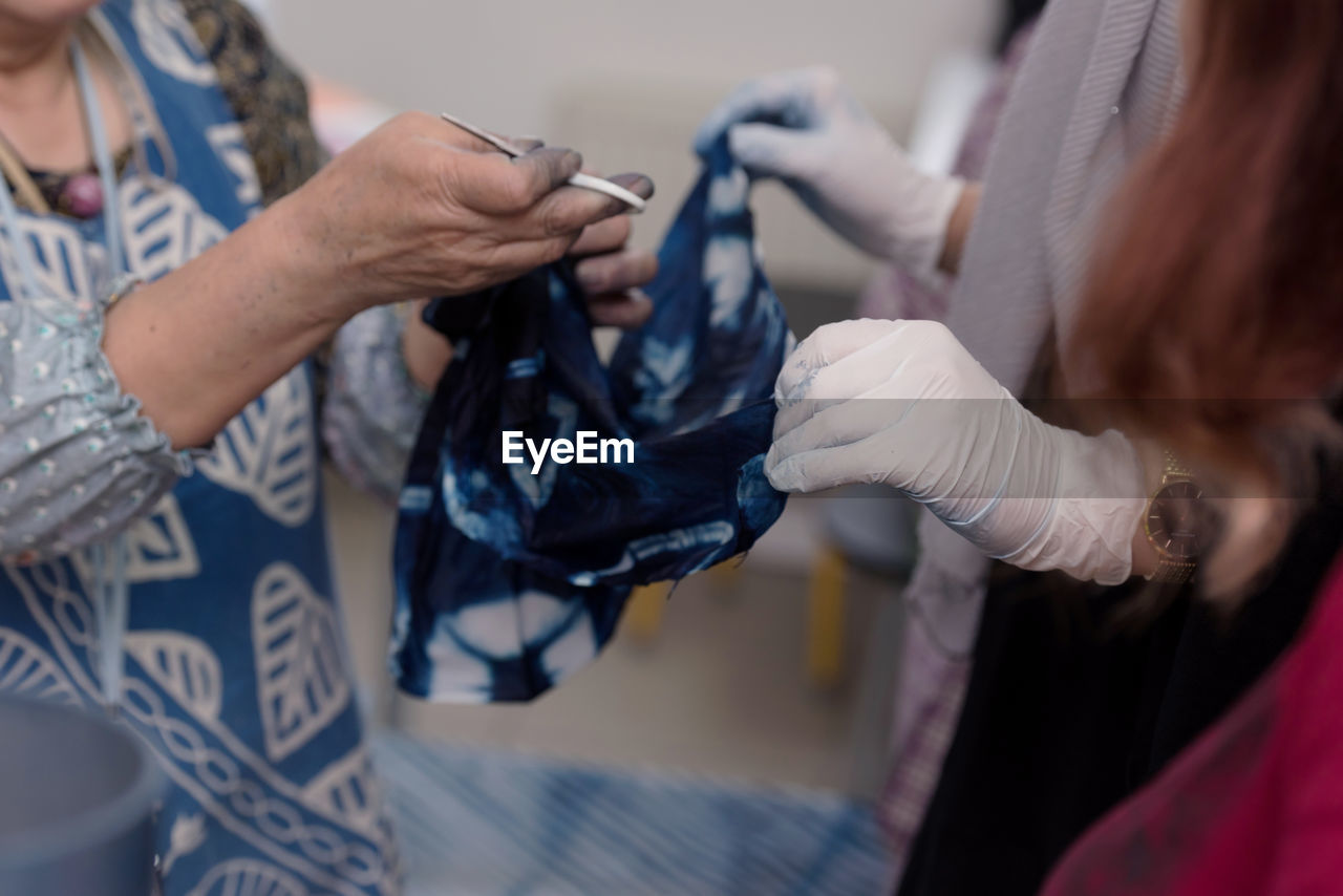 Midsection of woman holding textile at clothing store