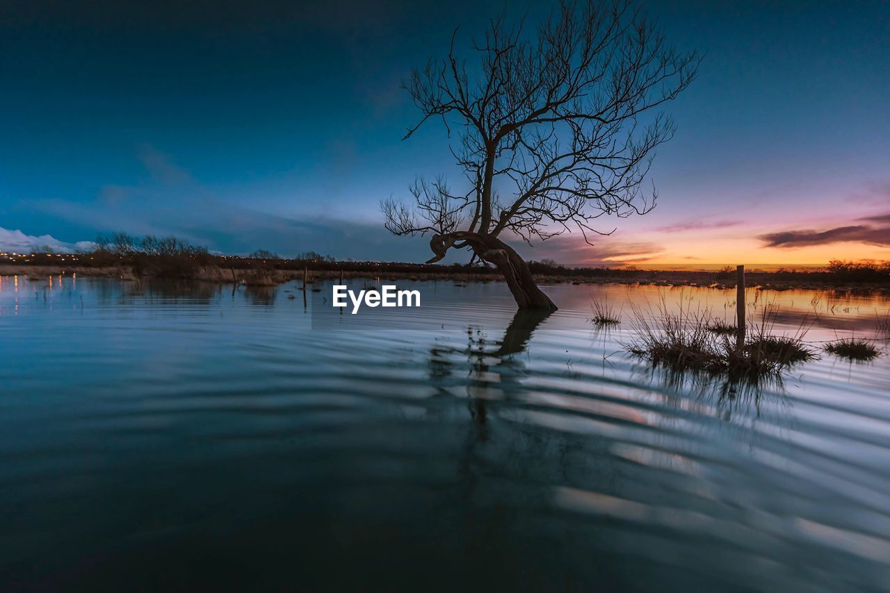 Scenic shot of calm lake at sunset