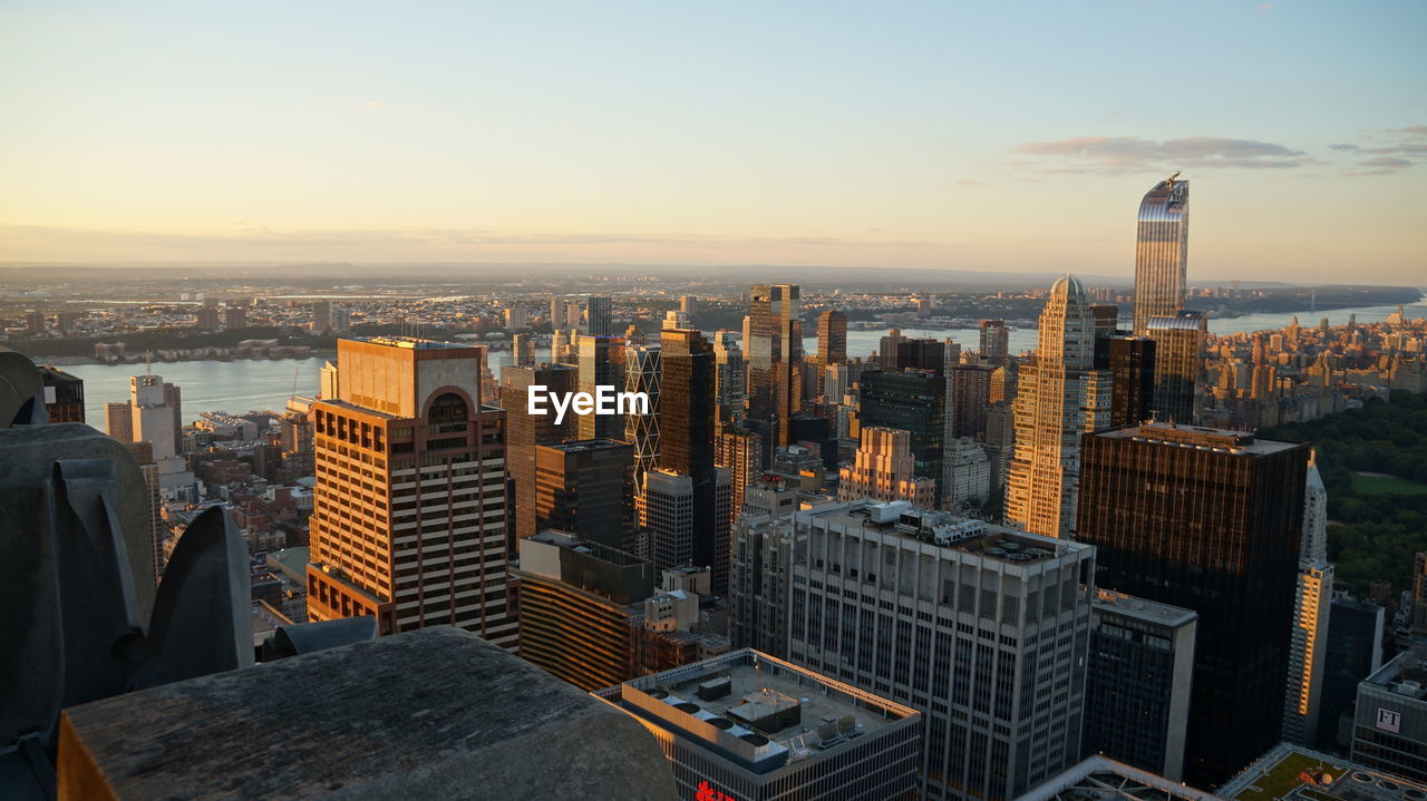 Aerial view of buildings in city against sky during sunset